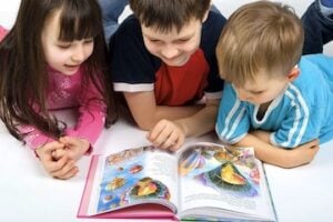3 kids reading a book
