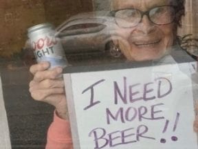 Photo of a 93-year-old lady holding "I Need a Beer" sign