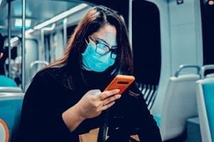 Photo of a female on a subway looking at her smartphone