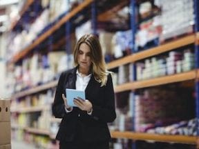 Photo of female in a warehouse holding a tablet