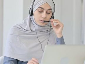 Image of a female with a headscarf working on a computer