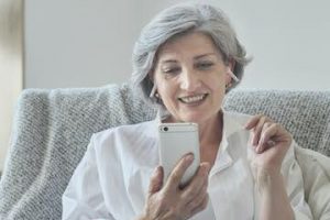 Photo of a middle-aged female using a smartphone.