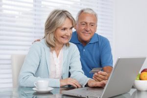 Photo of an older couple in front of a laptop