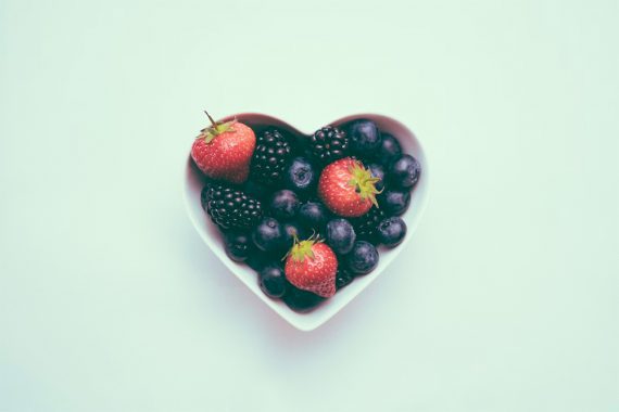 Pictures of strawberries, raspberries and blackberries in a bowl in the shape of a heart