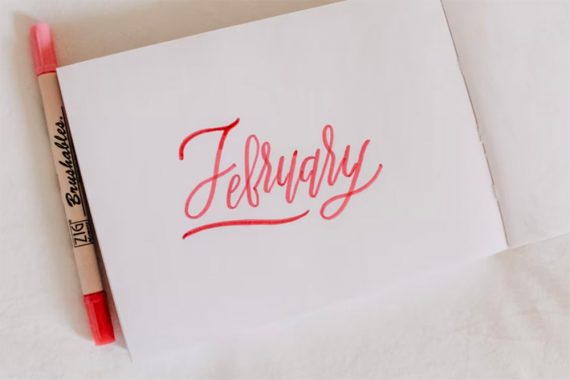 Photo of a card reading "February" with a pen beside it