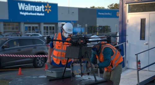 Foto de empleados de Walmart cargando un dron.