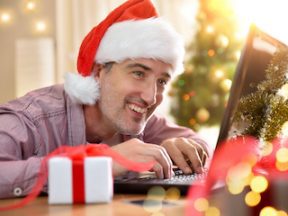 Photo of smiling male wearing a Santa hat