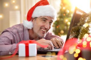 Photo of smiling male wearing a Santa hat