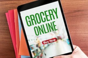 Image of a computer tablet with text "Grocery Online" on the screen