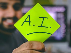 Image of a male holding a paper that reads "A.I."