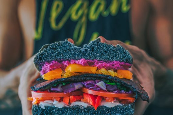 Image of a man holding a vegan sandwich.