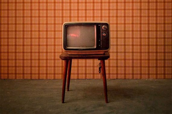 Photo of an old television on a wooden stand.