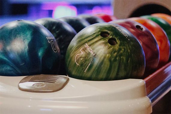 Bowling balls in a rack in a bowling alley