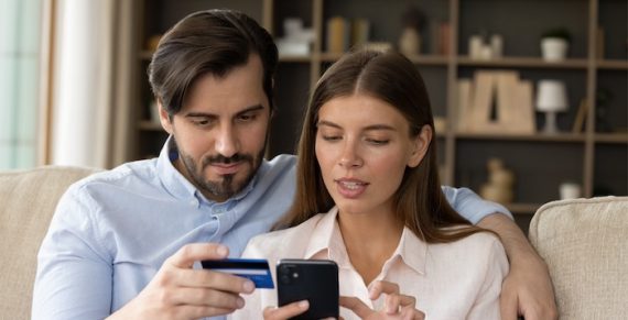 Focused millennial couple of consumers using banking app