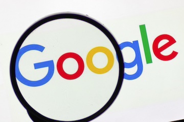 Google logo behind a magnifying glass