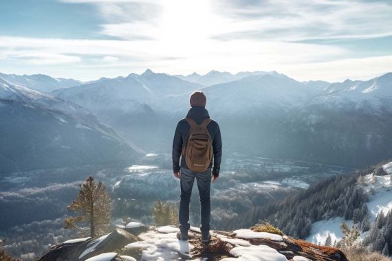 Photo of a male on a mountain looking at the horizon