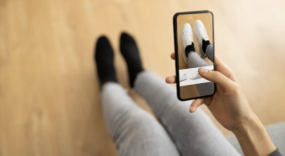 Photo of someone holding a smartphone with shoes on the screen