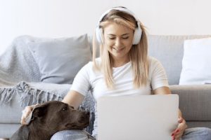 Photo from Notta of a female wearing headphones holding a laptop