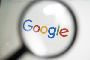 Google search logo on screen through a magnifying glass