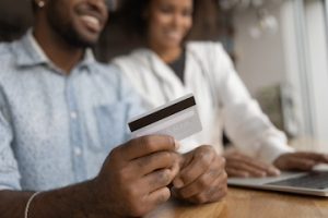 Happy African couple makes instant money transfer use online services