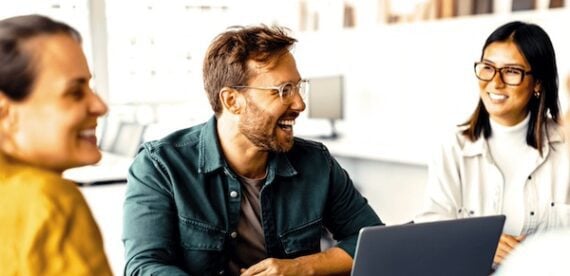 3 ecommerce entrepreneurs, all smiling, around a table
