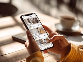 Image of a human hand holding a smartphone