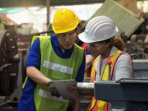 Photo of two workers (male and female) in a manufacturing environment