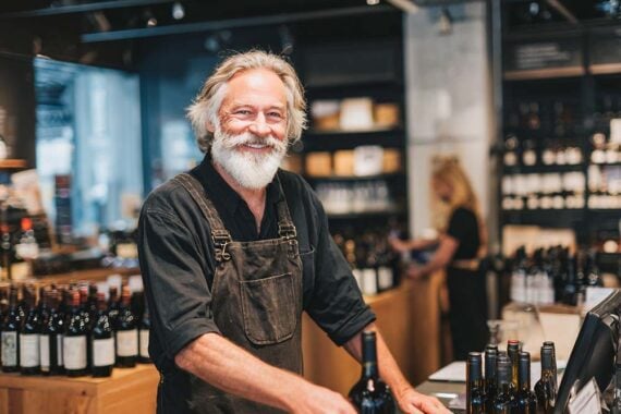 Image of a male merchant wiht a beard in his wine shop Image of a male merchant wiht a beard in his wine shop