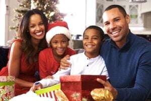 Mom, Dad, and two children in front of a Christmas tree
