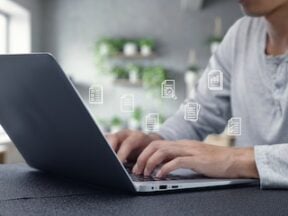 Image of human hands typing on a laptop