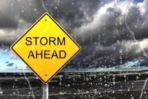 Road sign reading "Storm Ahead" amid a rain storm