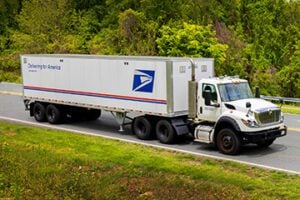 Photo of a USPS delivery semi-trailer truck