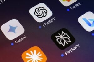 The Google Gemini, ChatGPT, Microsoft Copilot, Claude by Anthropic, Perplexity and Bing apps logos is displayed on the screen of a smartphone