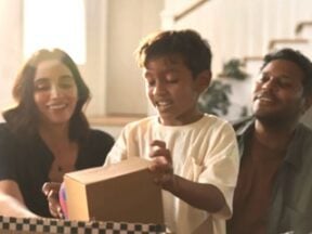 Image from Veho of a mom, dad, and preschool child opening a box