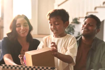 Image from Veho of a mom, dad, and preschool child opening a box