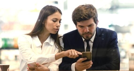 Female and male looking at a smartphone Female and male looking at a smartphone