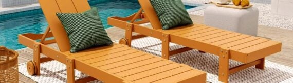 Two orange wooden Adirondack-style lounge chairs with green plaid cushions beside a swimming pool. Two orange wooden Adirondack-style lounge chairs with green plaid cushions beside a swimming pool.