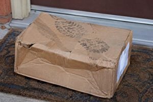 Fake photo of a smashed delivery box with a footprint on top