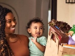 Instacart image of a mom and baby receivng a sack of groceries
