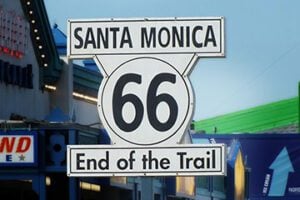 Road sign that reads " Santa Monica 66 End of the Trail"