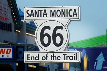 Road sign that reads " Santa Monica 66 End of the Trail"