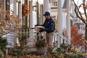 FedEx driver delivering a parcel to a residence