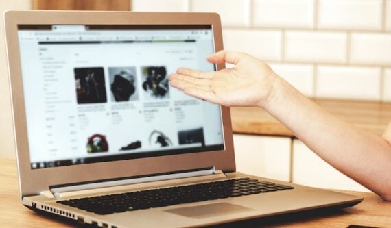 Photo of a laptop on a table showing ecommerce products Photo of a laptop on a table showing ecommerce products